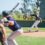 A baseball batter is on the plate while a pitcher is winding up to throw a ball at the hitter.