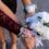 Close-up of white rose bouquet and floral wrist corsages, including white, pink, and burgundy flower accents.