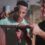 A young man using a hammer on a wooden project while an older man guides him in a carpentry workshop setting.